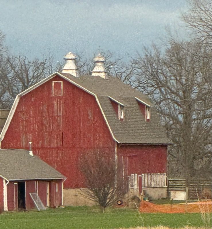 Red gambrel roof barn with cupolas