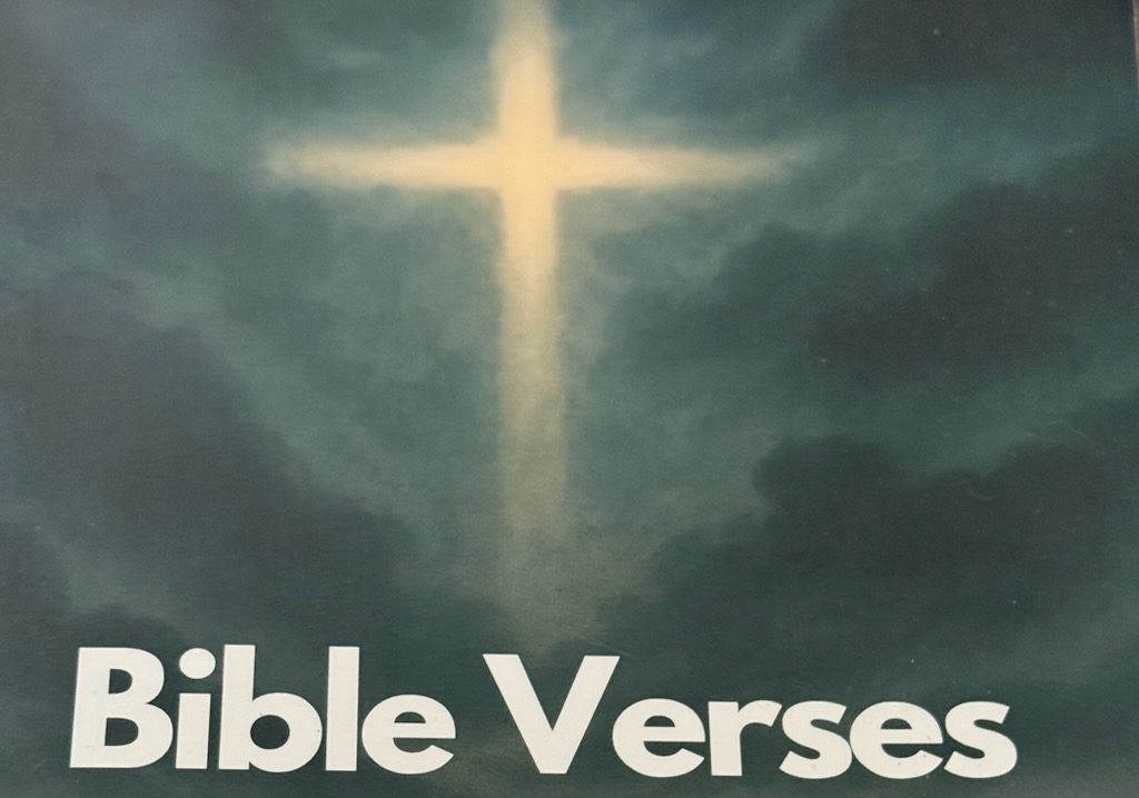 Glowing cross in cloudy sky over Bible Verses