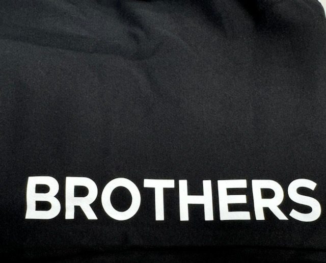 White "BROTHERS" text on black fabric