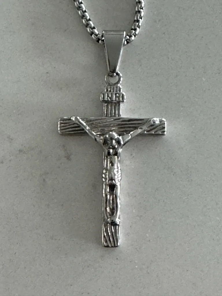 Textured silver crucifix pendant necklace close-up