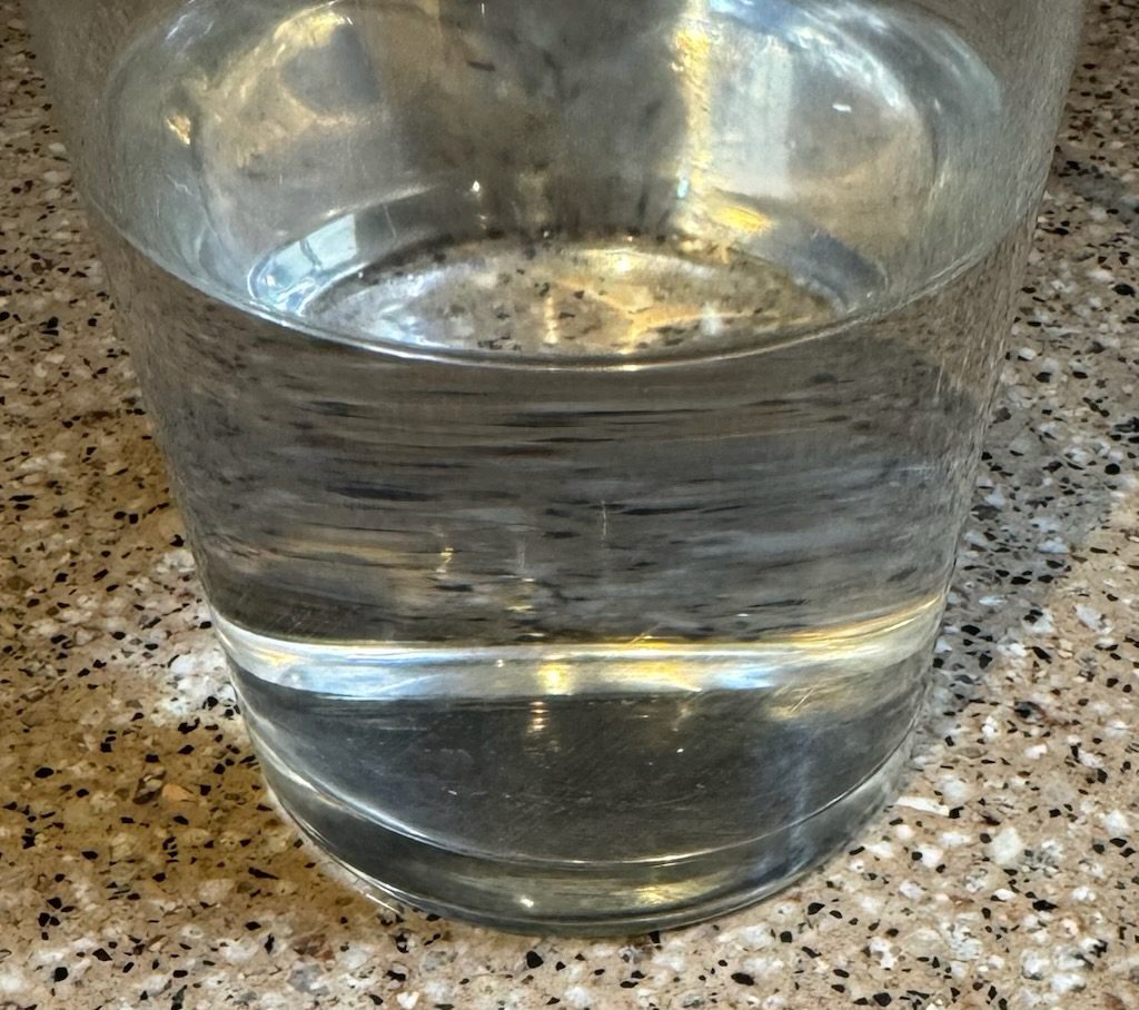 Glass jar filled with clear water on countertop